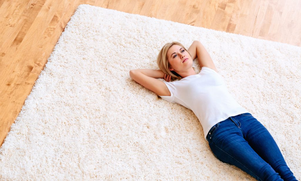 Young woman lying down on a carpet
